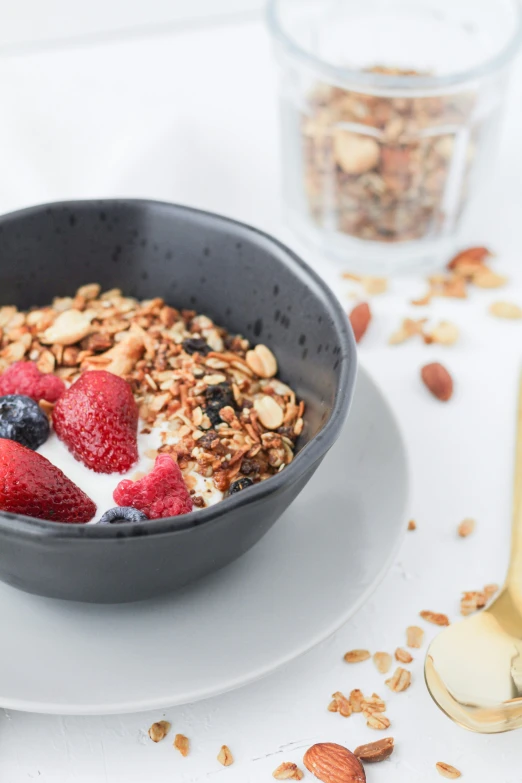 there is a bowl filled with some granola and strawberries