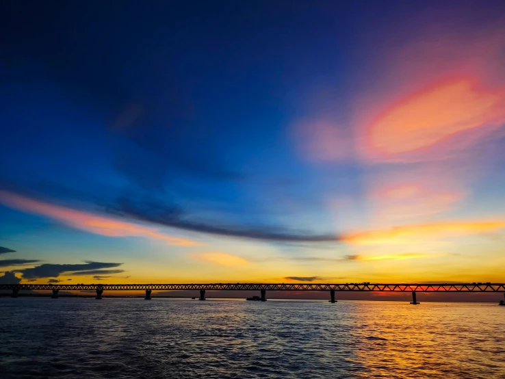 a river with bridges in the sky during sunset