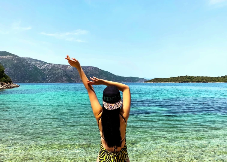 a woman holding a kite while standing in the ocean