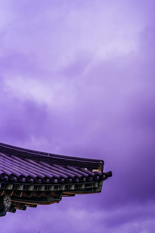 an oriental style building beneath a blue sky with clouds