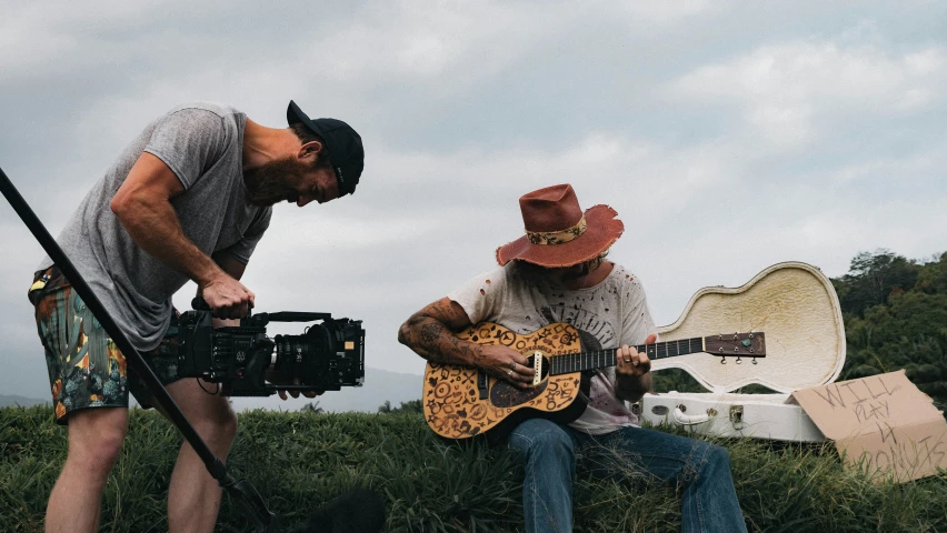 two men, one with a guitar and the other playing the ukulele