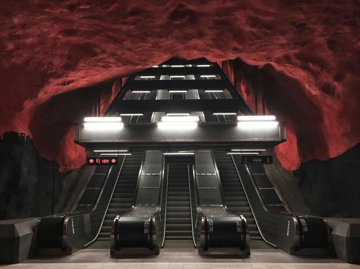 the escalator is full of luggage with red walls