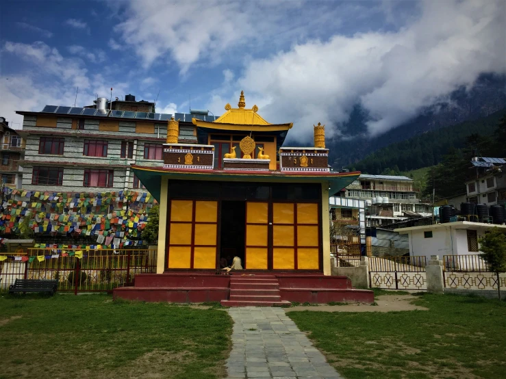 a small yellow building sitting on top of a green field