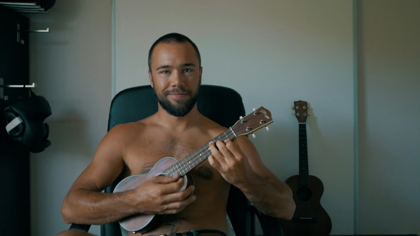 a man with a guitar sitting down