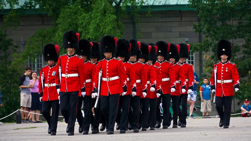 military men and officers in red uniform marching with an official man