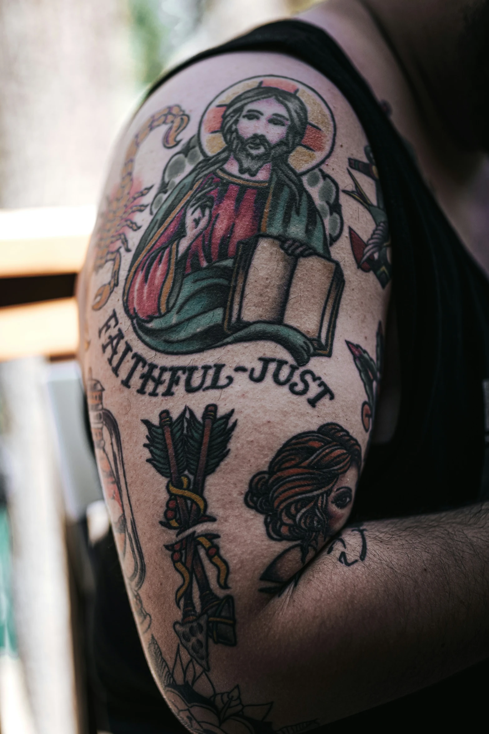 a close up of a person wearing a religious tattoo