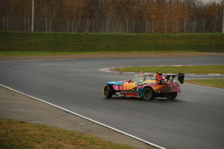 colorful race car speeds along an empty track