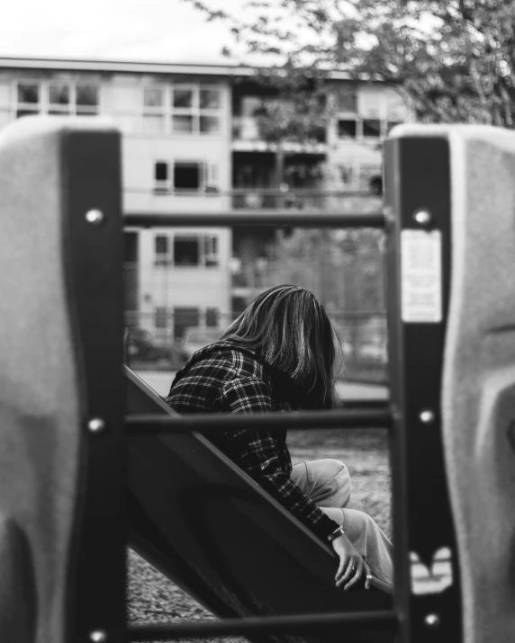 a person sitting down with their feet up on the side of a seat