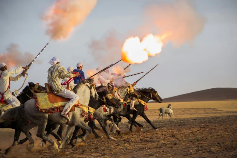 a bunch of people riding horses with smoke billowing from the back