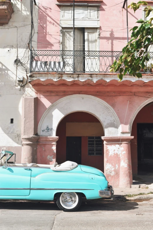 an old car is parked on the side of a street