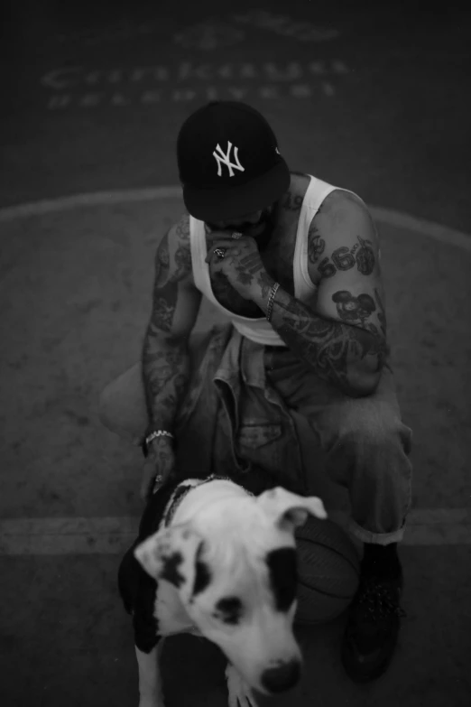 a person sitting on a curb next to a small dog