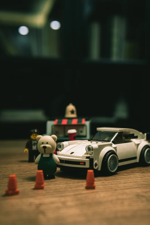 two toy cars sit in front of lego characters