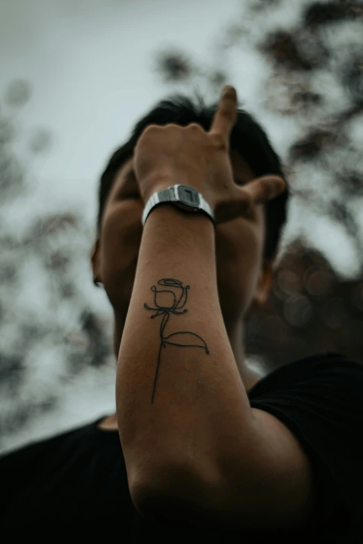 man with a tattoo pointing down