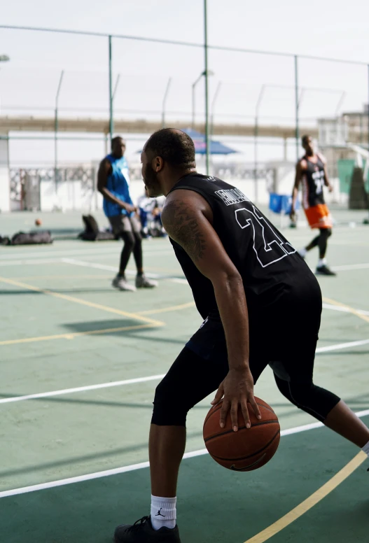 a man holding a basketball standing on top of a basketball court