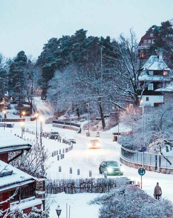 a snowy view of a town from above, with a small green car in the snow