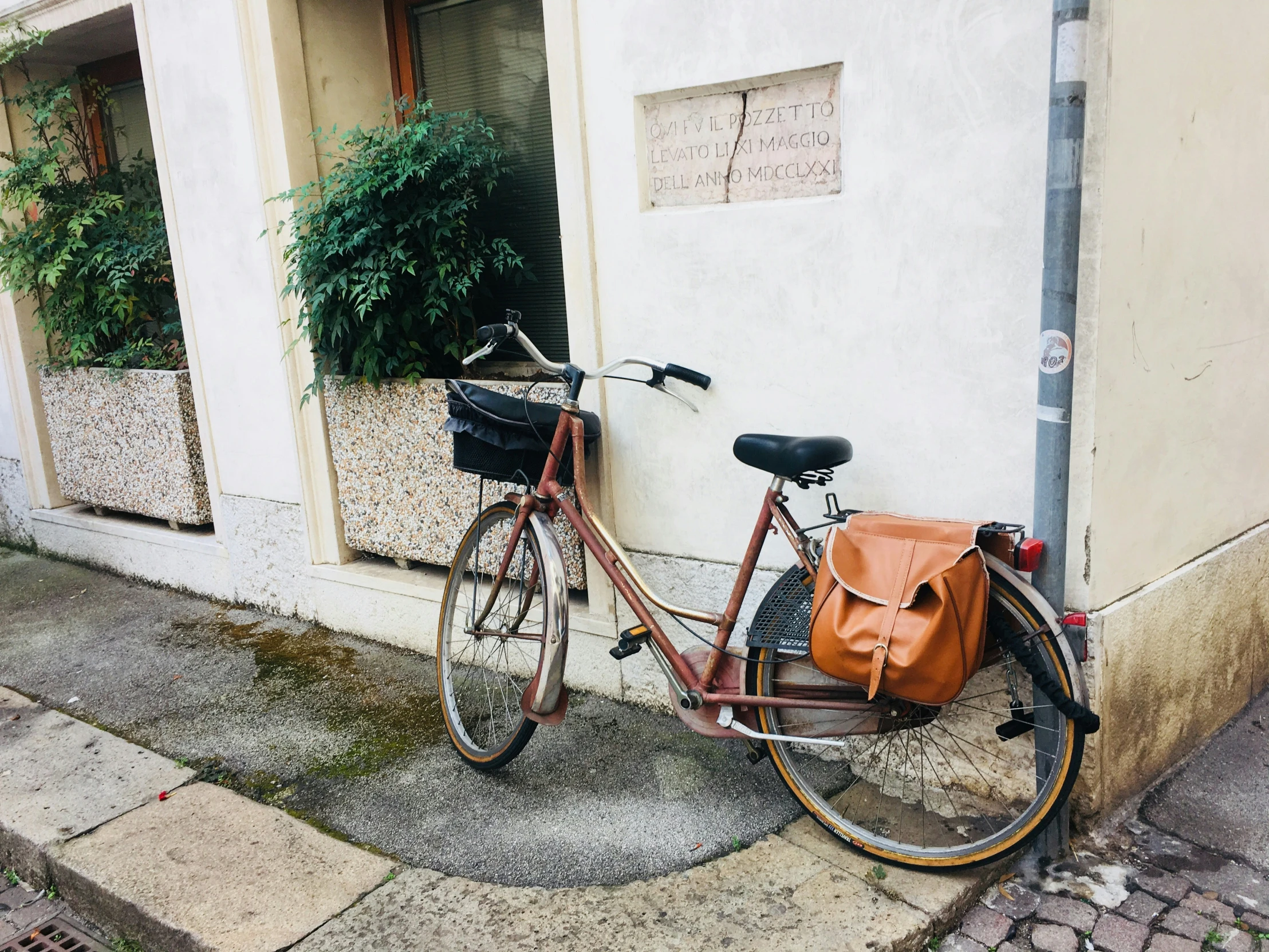 the bicycle is leaning against the wall next to a purse