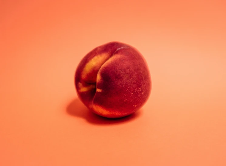 a peach fruit in a red and orange background