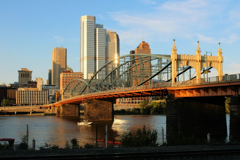 a bridge on a river with a city in the background