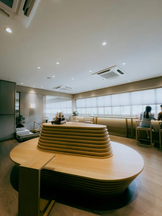 a large room has people in chairs at the counter