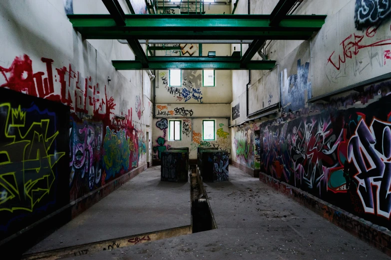a hallway with many graffiti on the walls