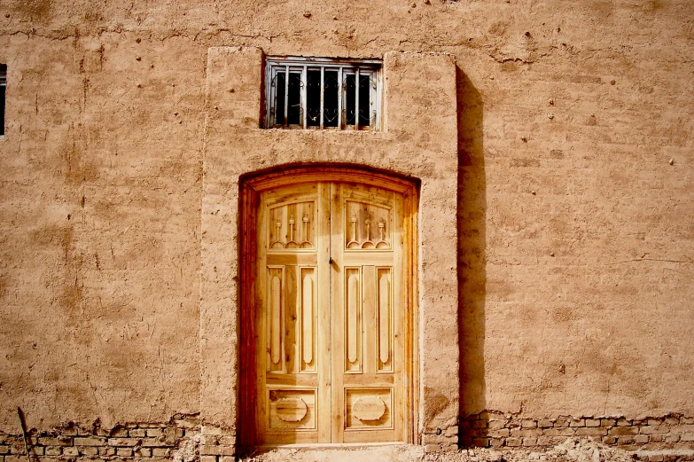 a wooden door and window near a wall