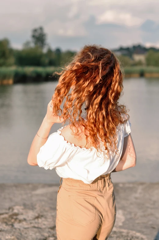 a woman that is walking by some water