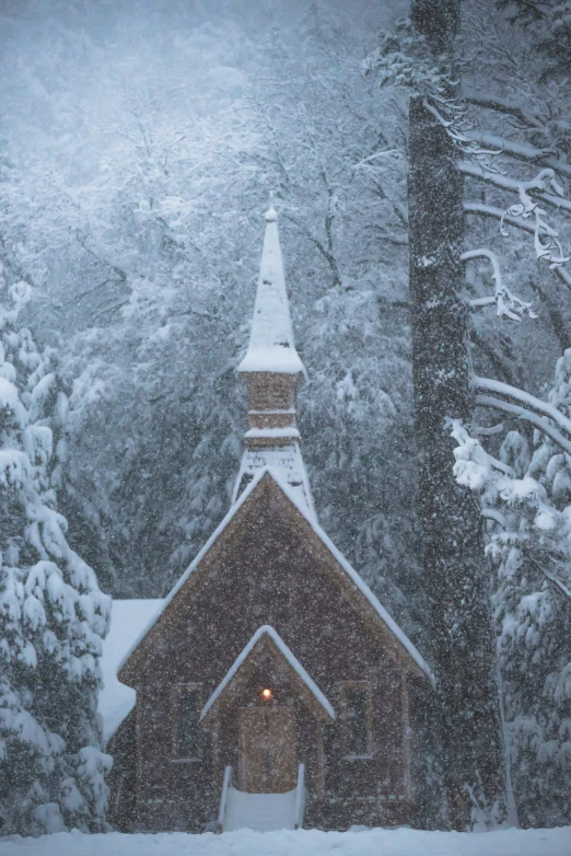 a church covered in snow next to some trees