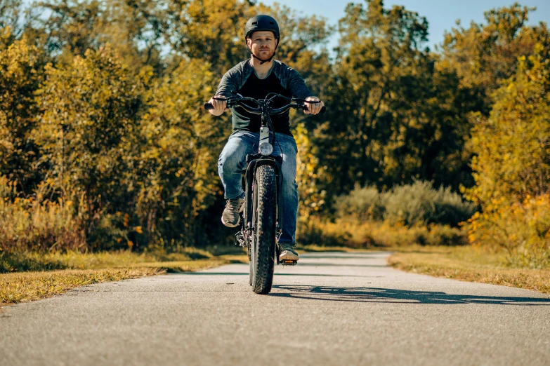 a man riding a bike down a dirt road