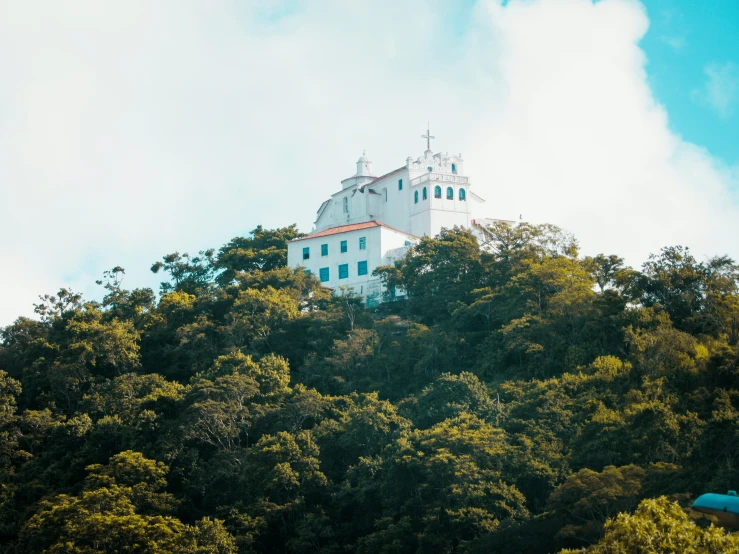 a very tall building atop a tree covered hillside