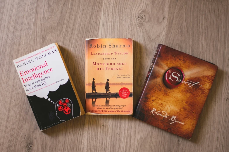 three books laid out on a wood table