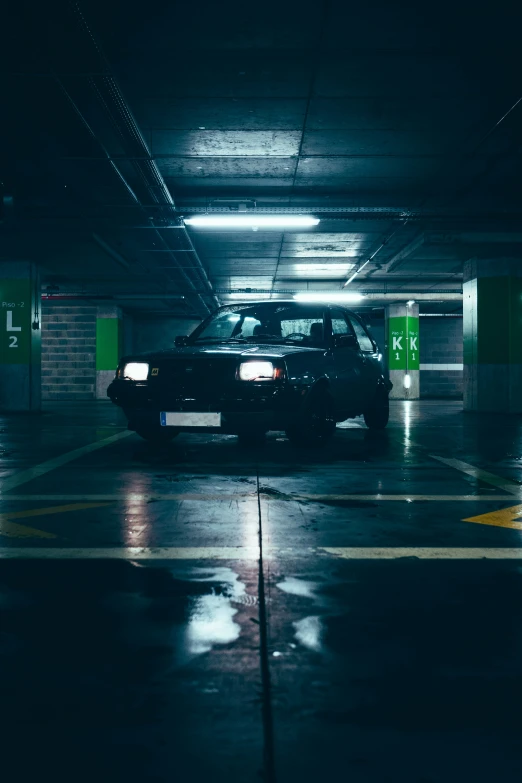 a black four door car parked in an underground parking garage