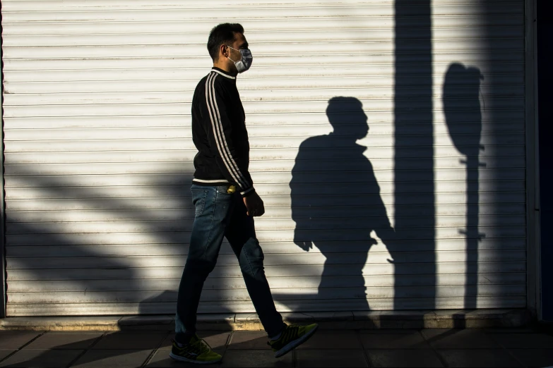 a man walks by a tall white building