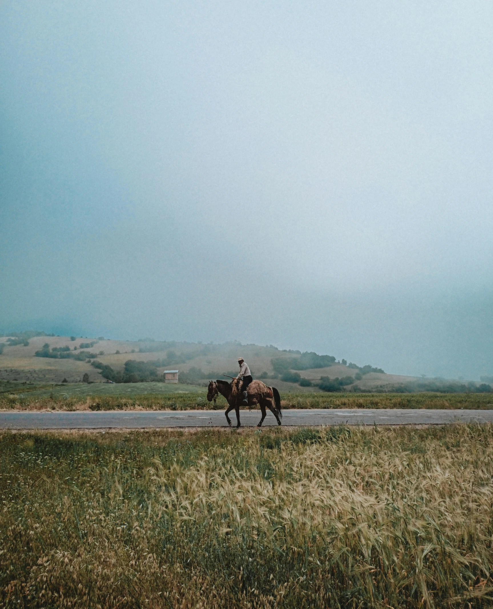 the man is riding his horse down the road