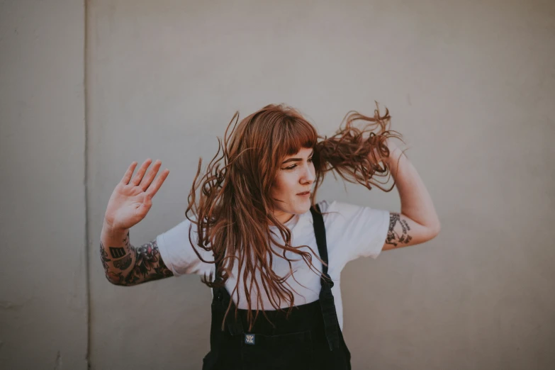 a young woman holding her hair in the air