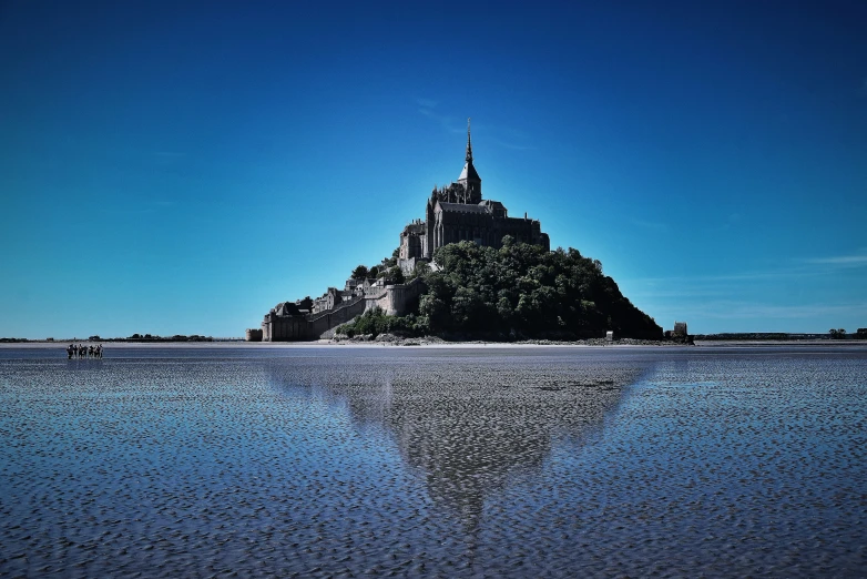 the water is crystal blue and reflects an island