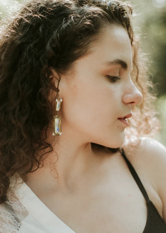 a woman wearing large earrings looking away