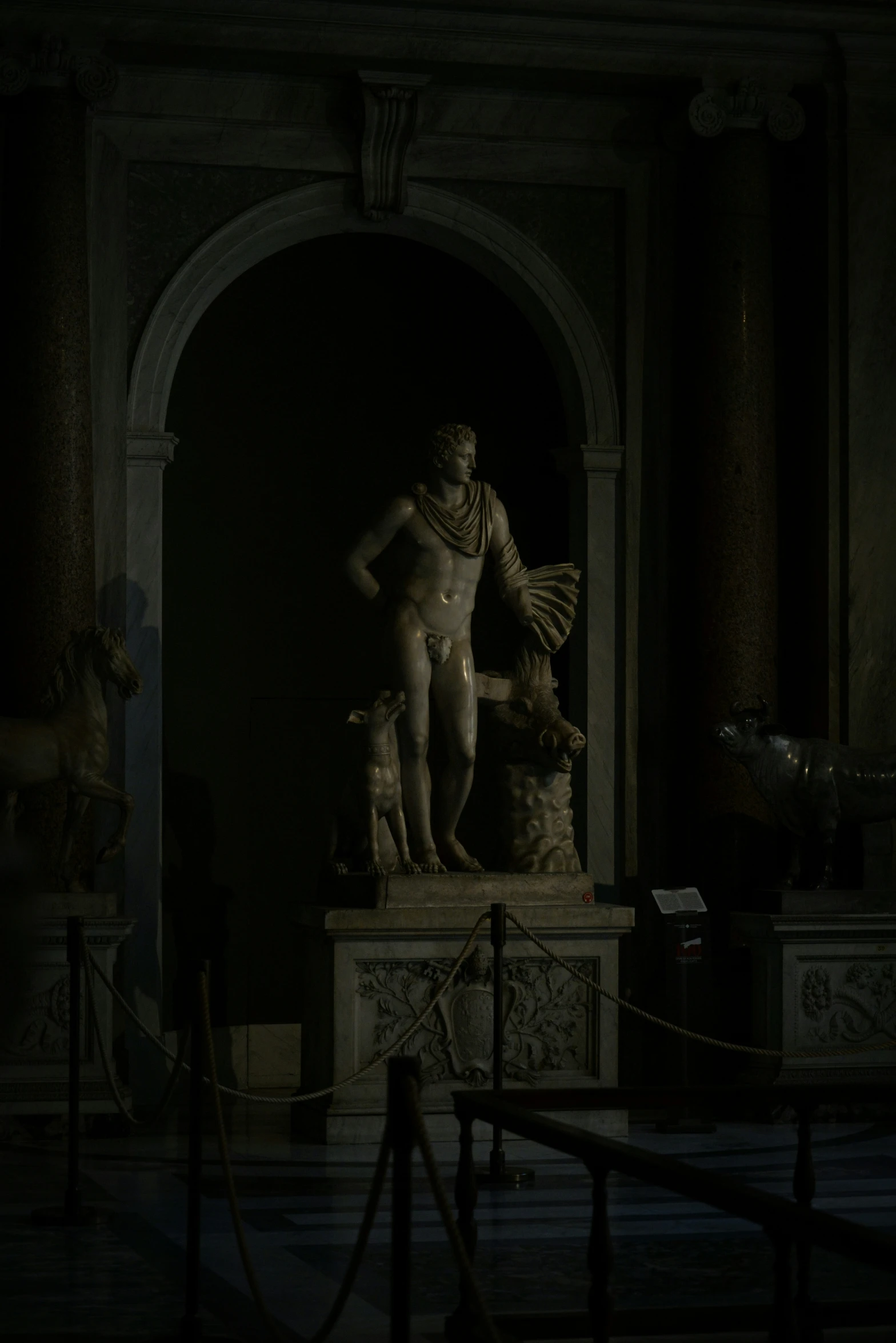 statues are set against a wall in a room