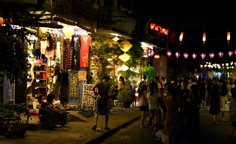 a crowd of people walking on a street next to lights