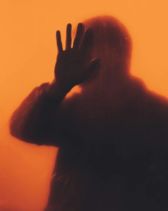 a silhouette image of a person with their hands up