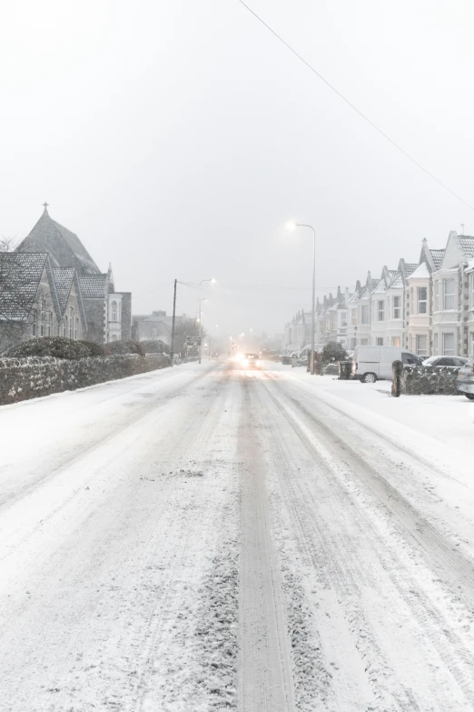 street filled with snow and parked cars on it