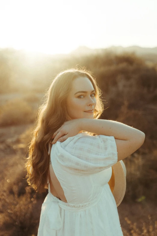 a woman in white is standing in the middle of a field