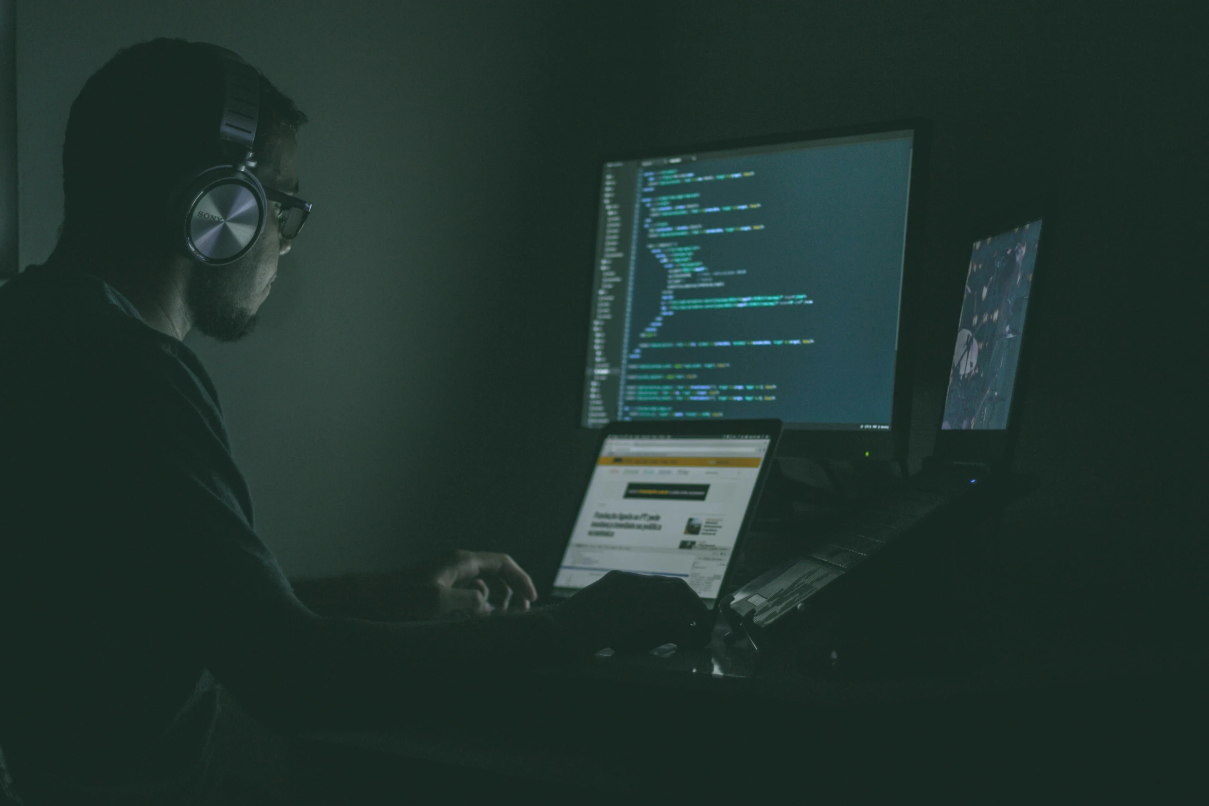 a man in dark room using a computer