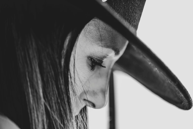 a girl wearing a hat while holding her cell phone