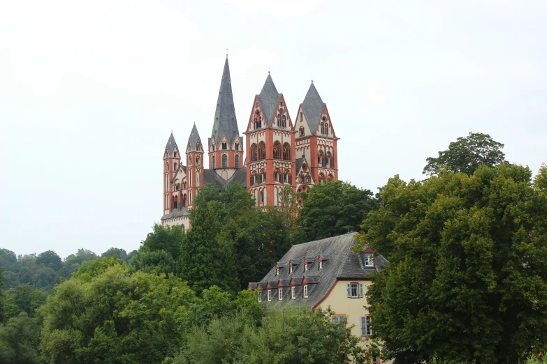 a large building sitting among the trees and on top of a hill