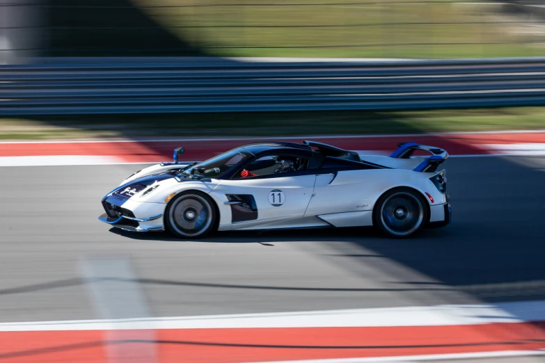 a supercar driving on a track, in motion