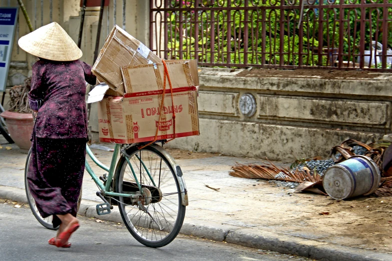 a woman riding on the back of a bike with boxes strapped to the side