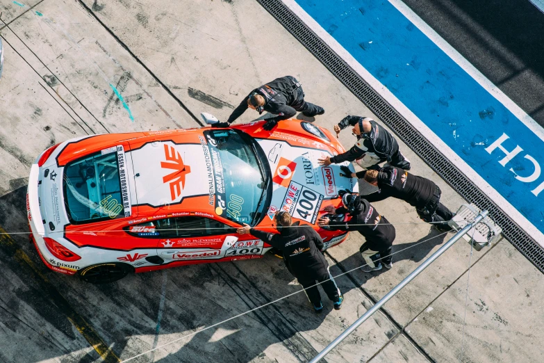 some men standing around a small red race car