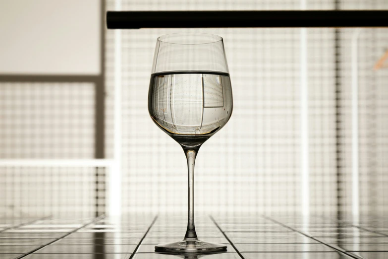 a glass of white wine on a tiled floor