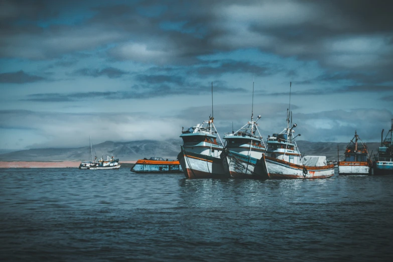 multiple docked ships sitting at the edge of a body of water