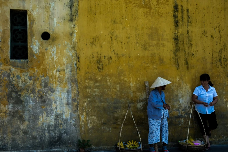 a woman in a hat is standing with two baskets on the ground